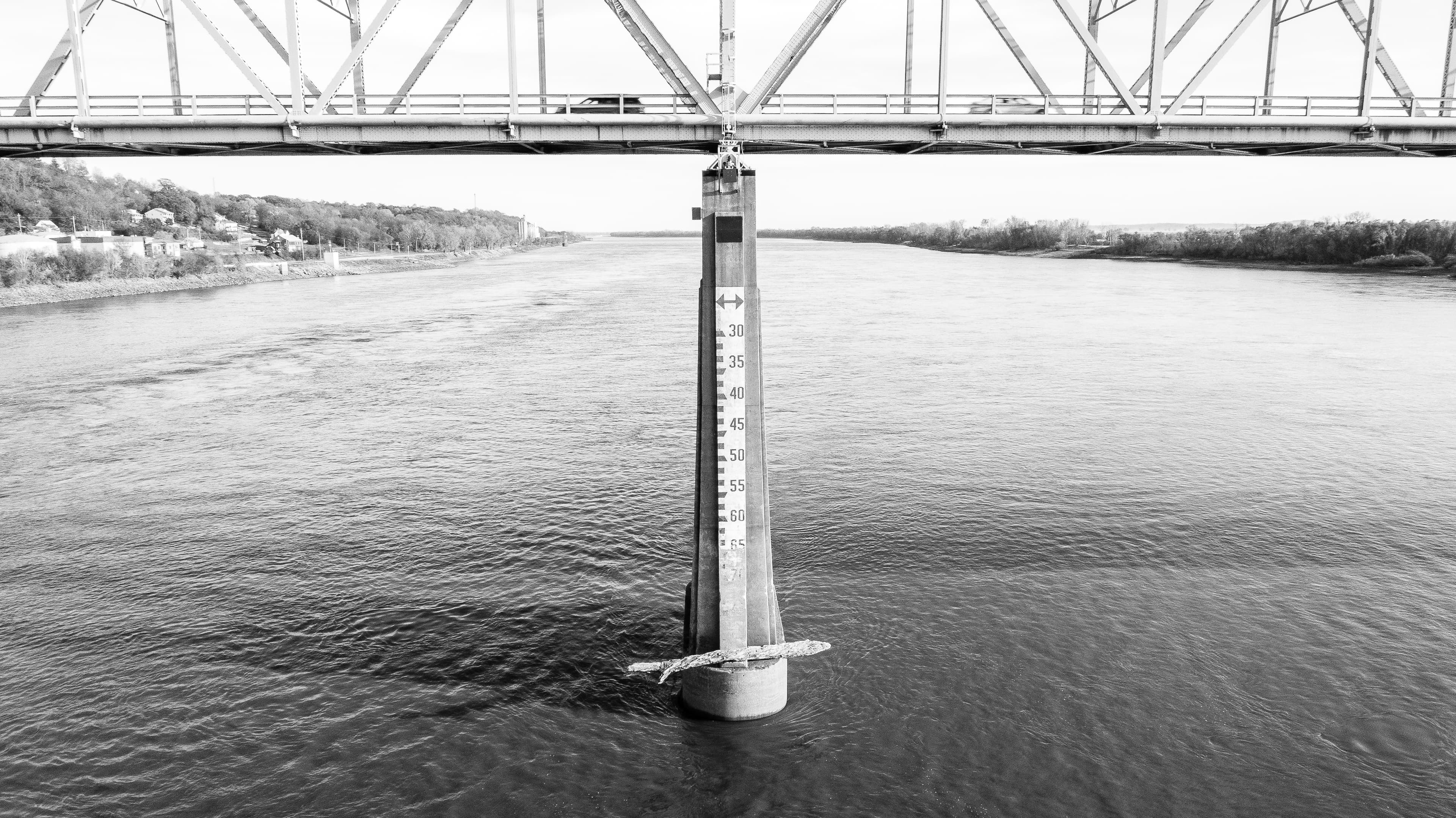 Black-and-white head-on view of a Chester Bridge pier with river-depth gauge numerals