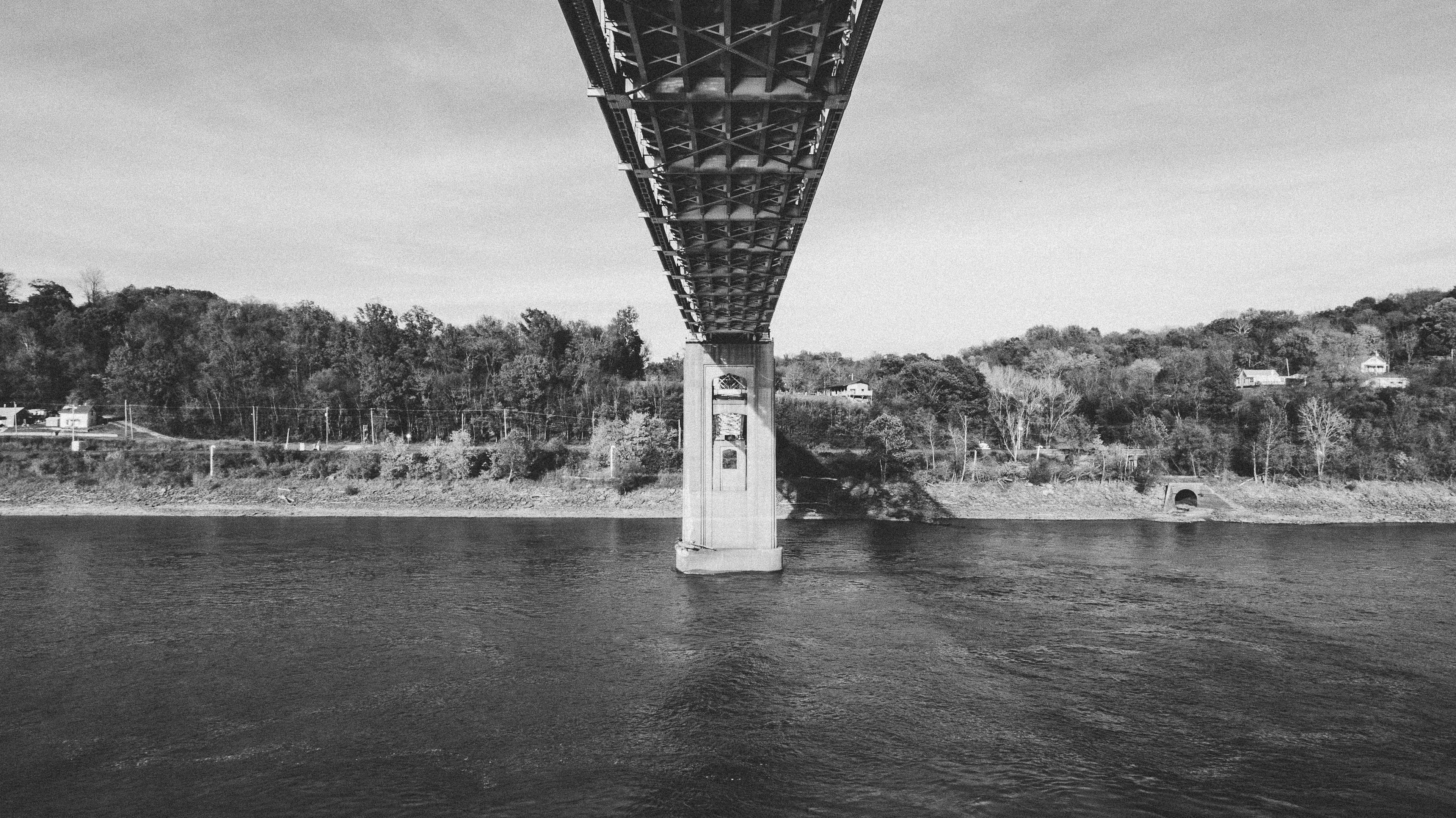Black-and-white view beneath the Chester Bridge deck toward its central pier