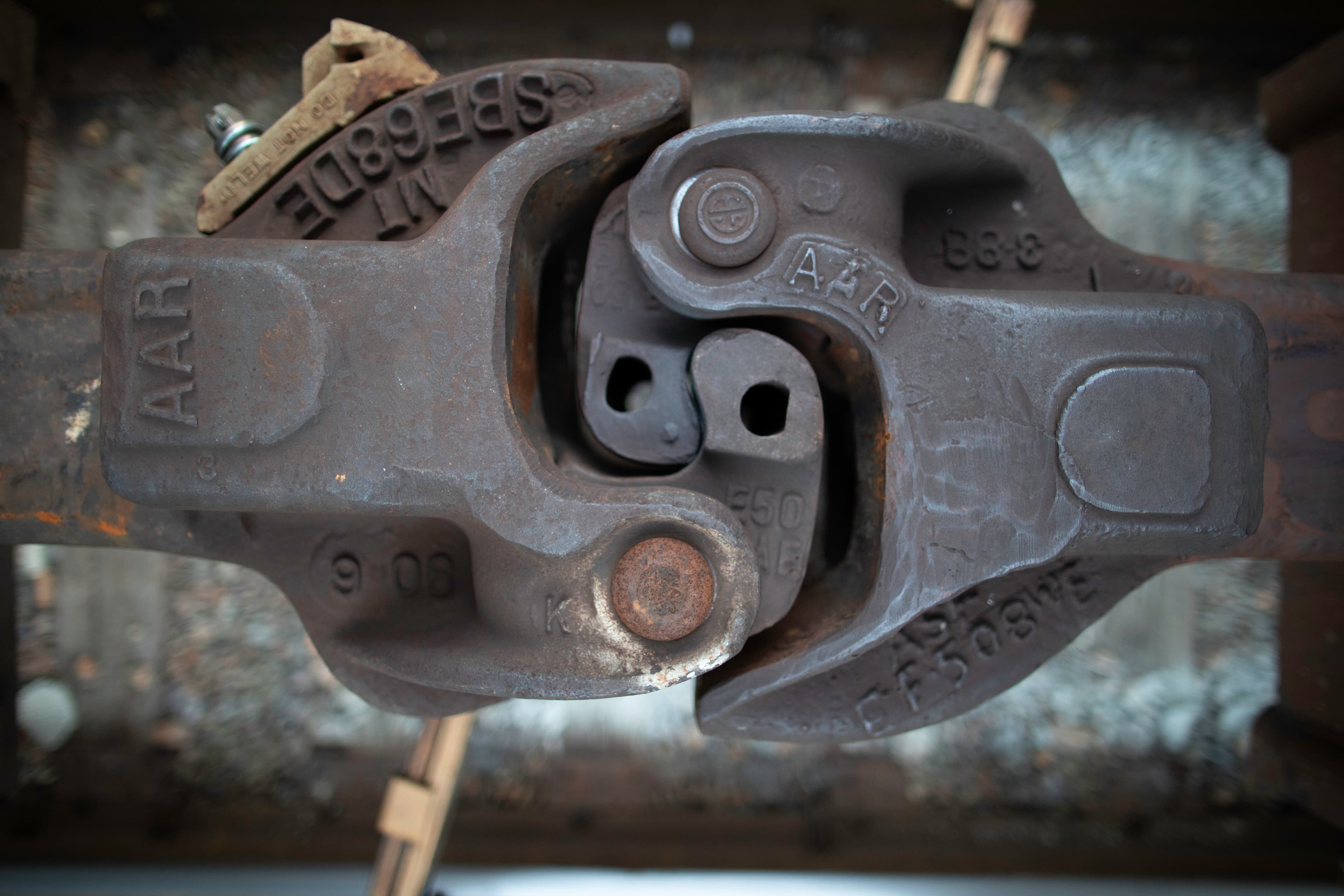 Close view of an interlocking rail coupler with cast markings